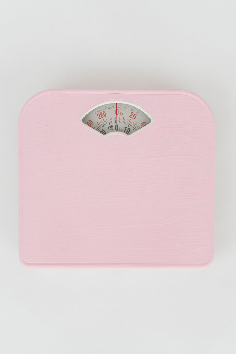 Simple pink bathroom scale on a white background